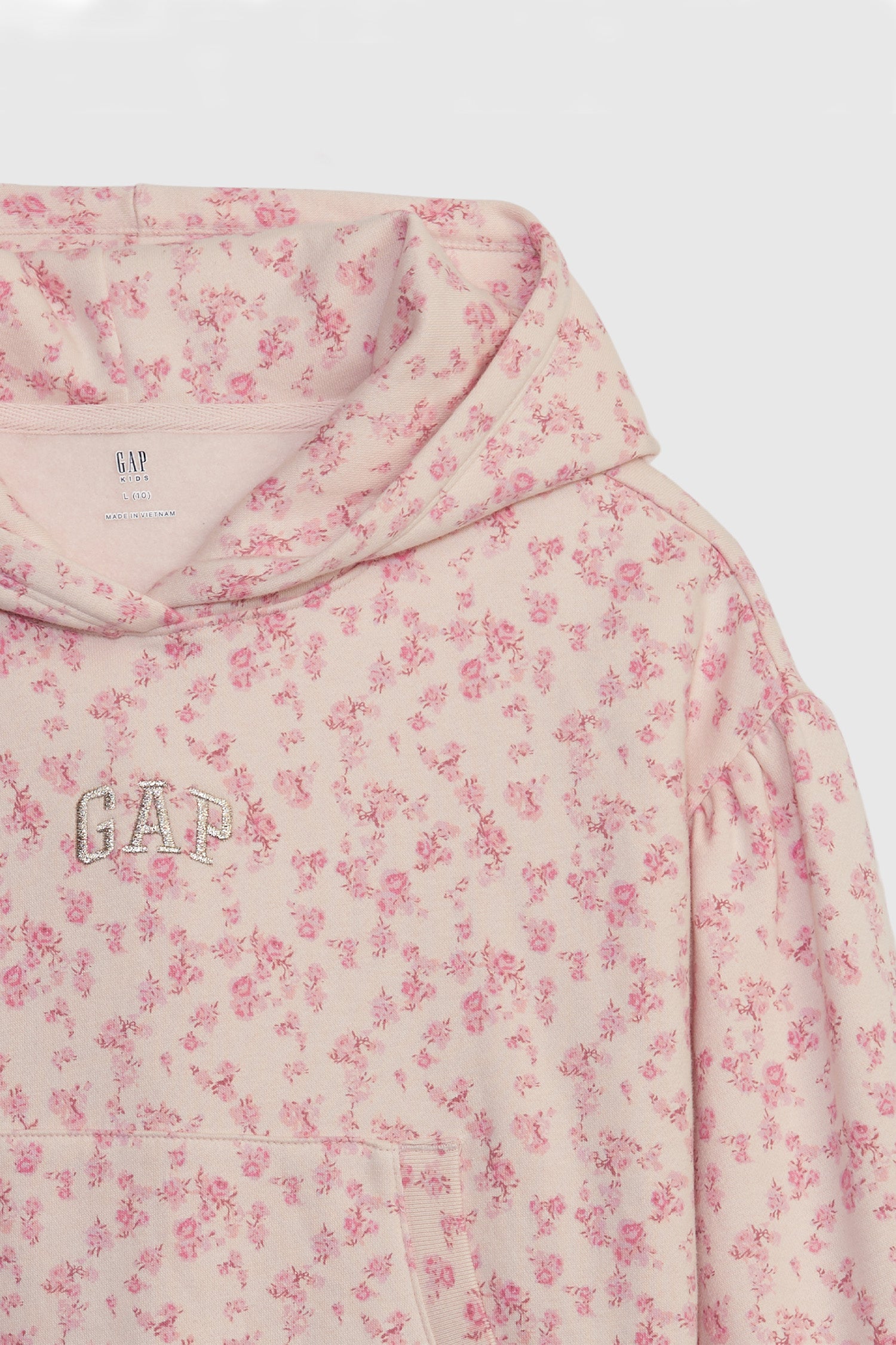 Close up image detailing kids pink floral crop hoodie with GAP arch logo on chest and front pocket