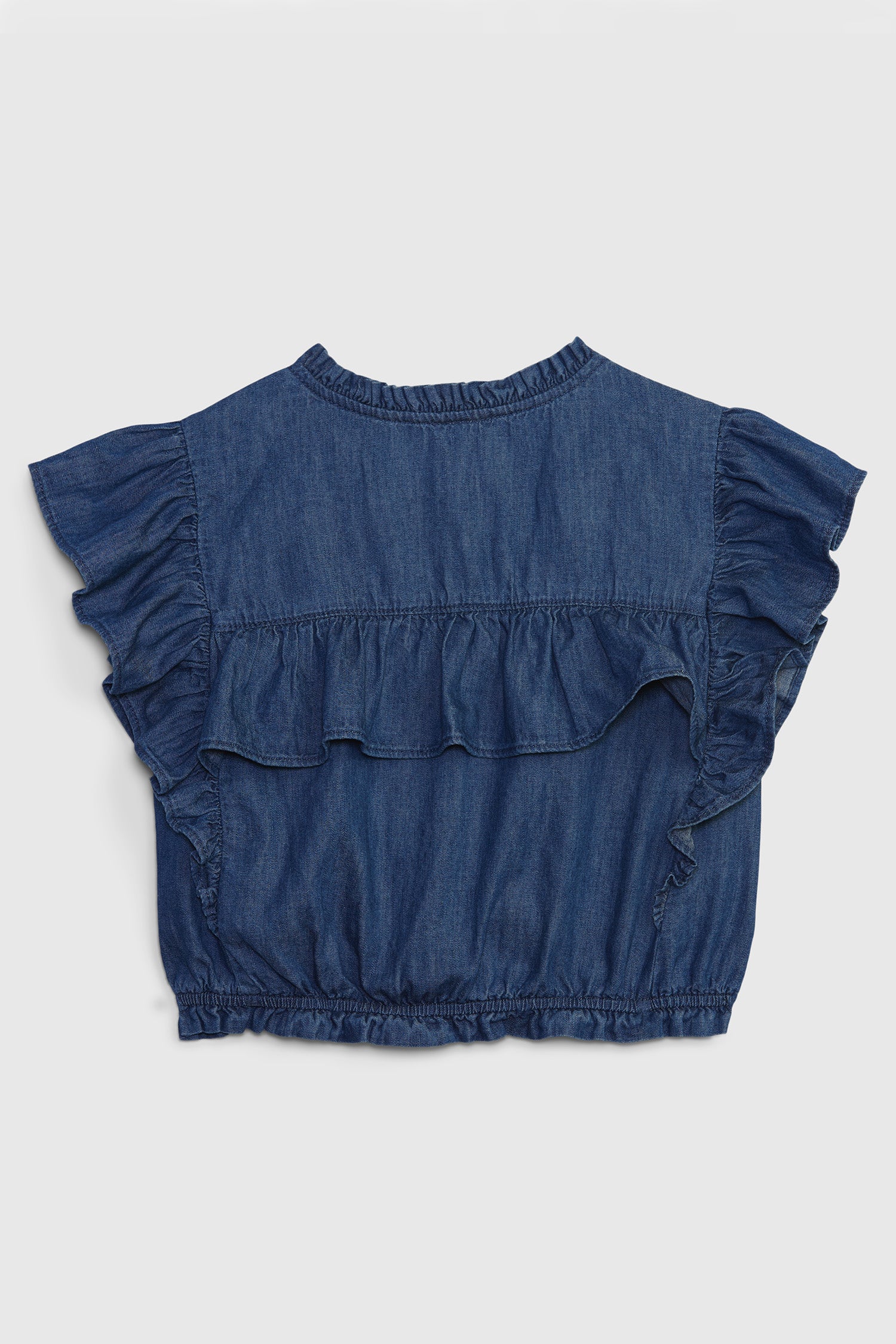 Back image of kids denim ruffle top with buttons at front and ruffled short sleeves. Has a ruffle going across the back. 