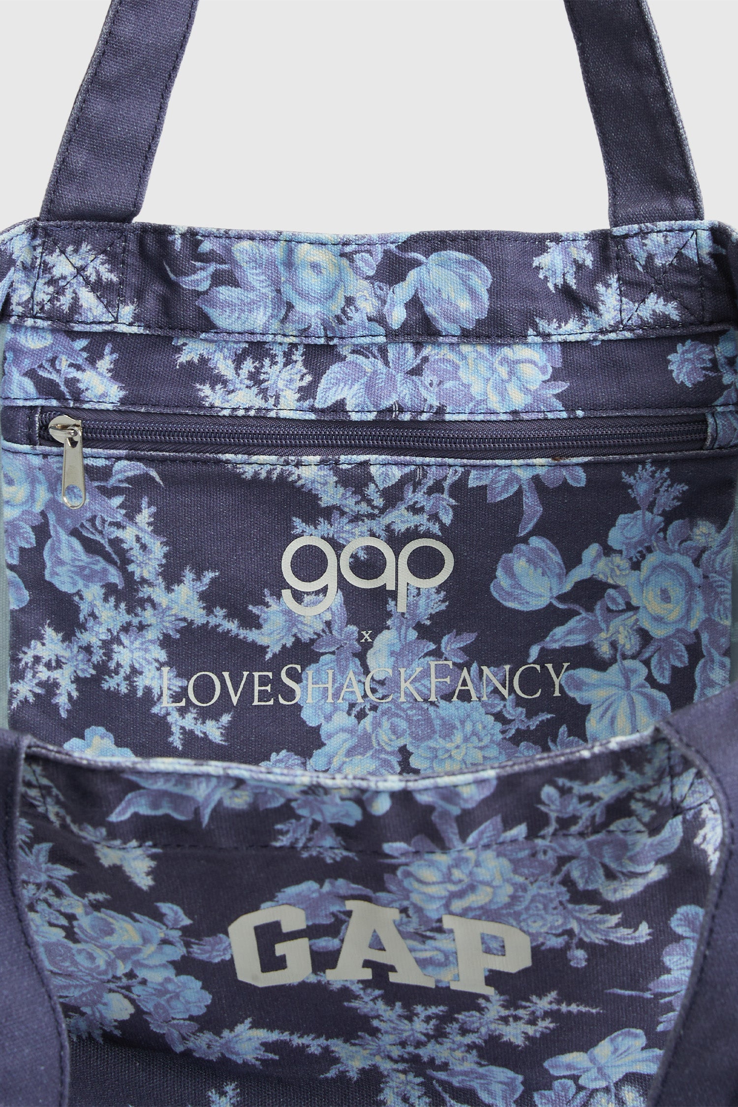 Image showing inside pouch and zipper detail of floral tote back with GAP arch logo at front. Says gap x LoveShackFancy on inside pouch