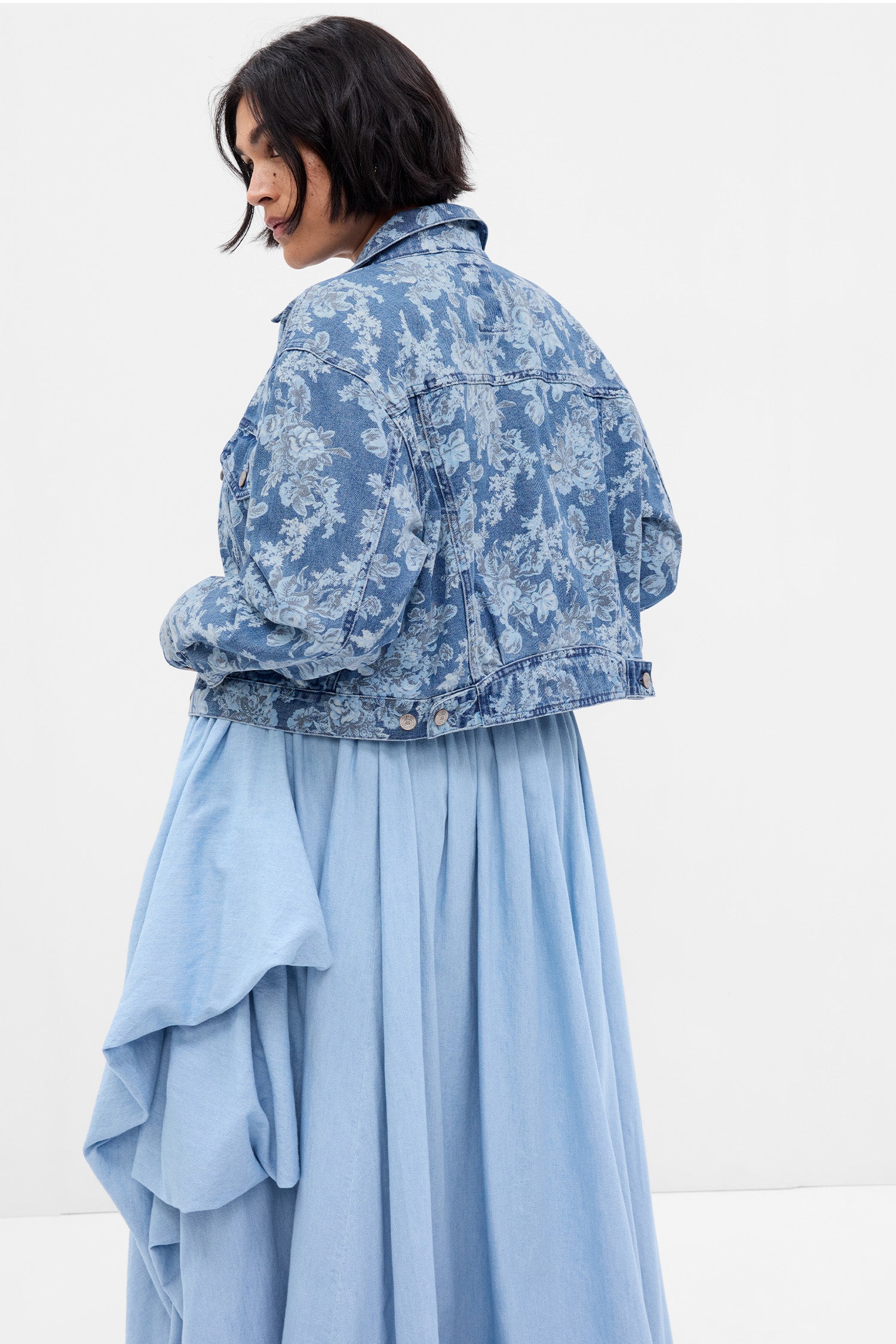 Back image of model wearing blue denim floral jacket