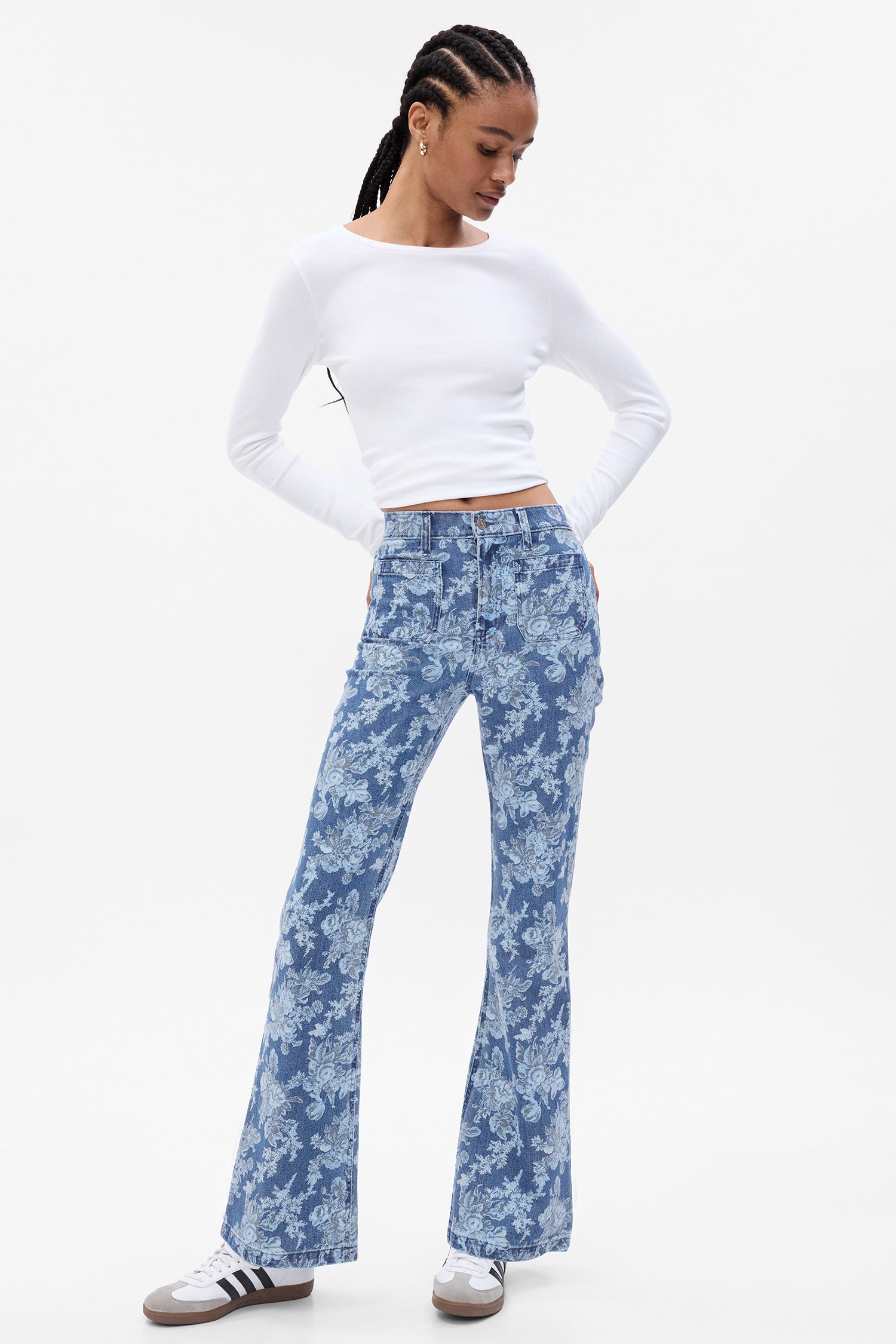 Model wearing blue floral high rise flare jeans with square pockets at the front