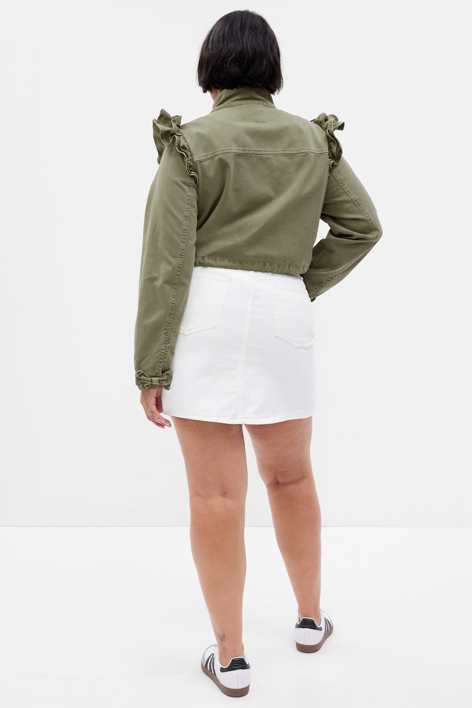 Back image of model wearing green crop utility jacket with ruffle shoulders