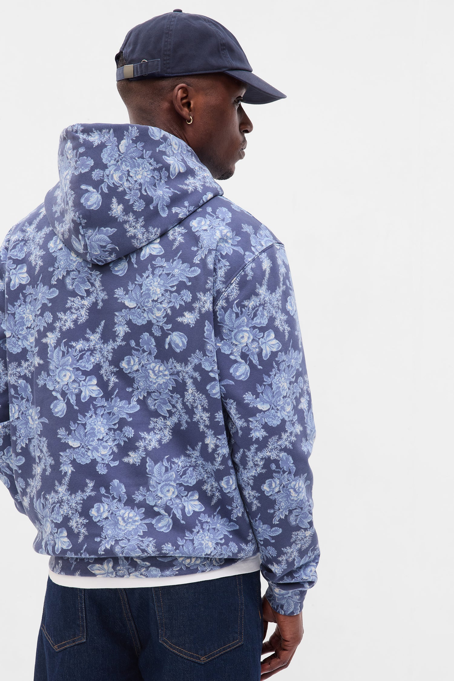 Back image of model wearing men's blue floral hoodie with GAP logo at chest
