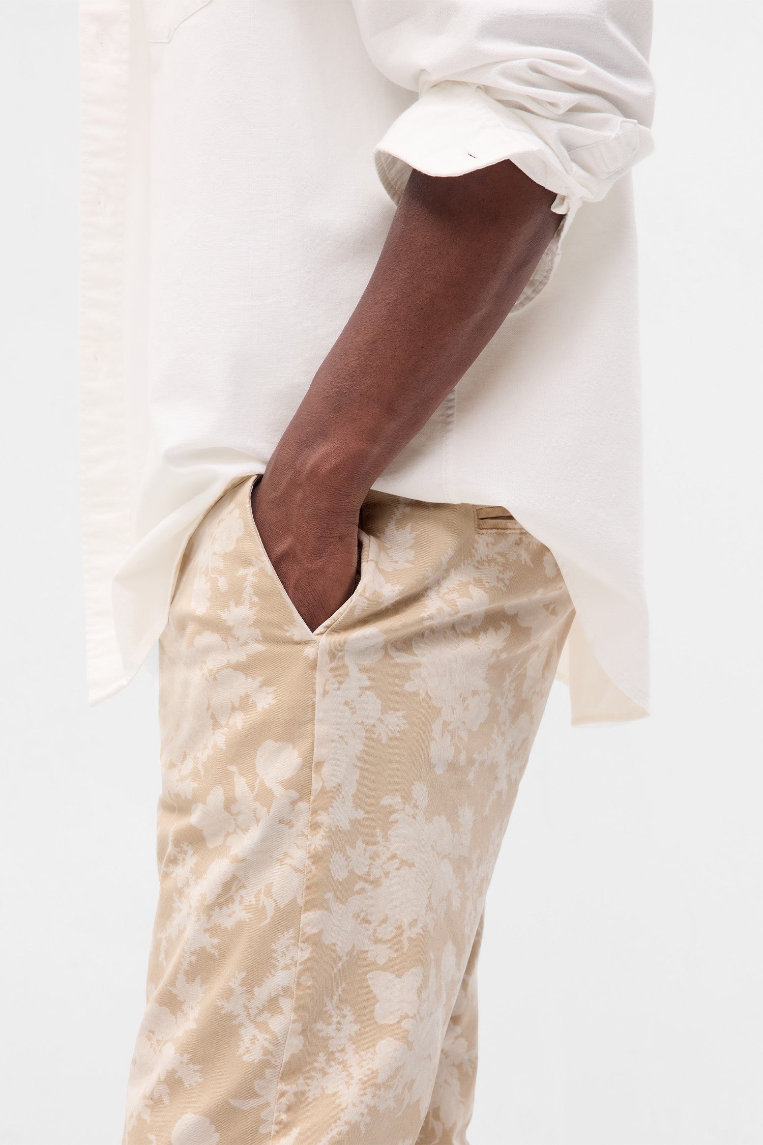 Close up image detailing floral pattern and pockets on men's beige floral khakis.