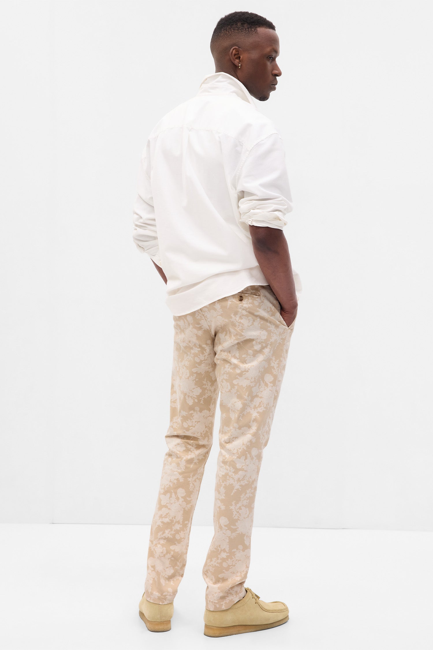 Back image of model wearing men's beige floral khakis.