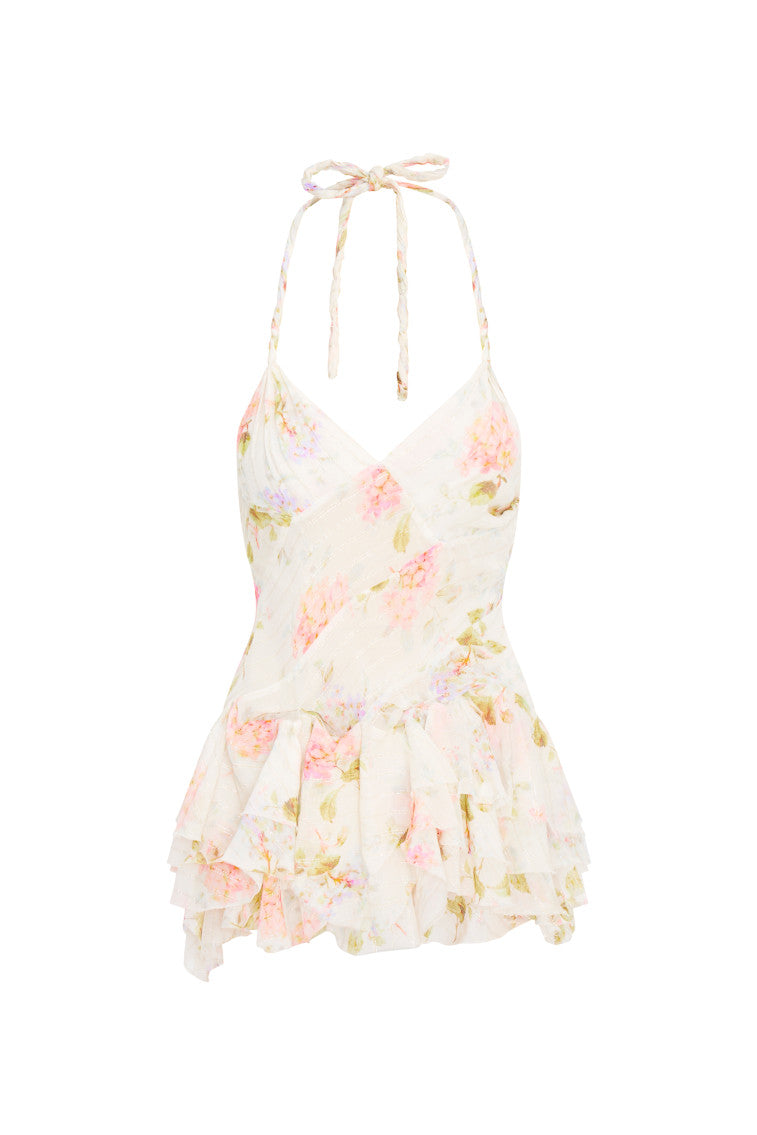 Large-scale floral printed mini dress beginning with twisted braided straps you can tie for a halter. Asymmetrical seams line the piece above a handkerchief skirt.