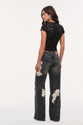 Black wide-leg jeans with cream lace applique on front panels and pockets.