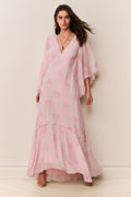 Woman wearing a pink floral dress against a white background