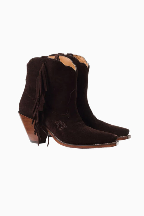 Pair of brown suede cowboy boots with fringes on a white background
