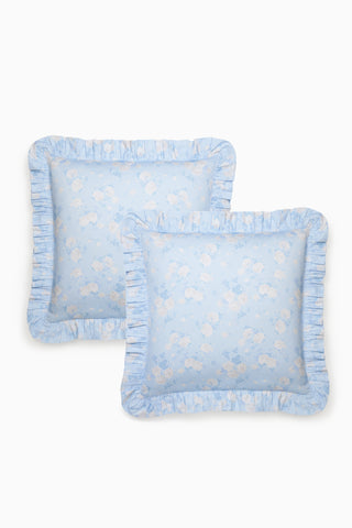 Two light blue pillows with ruffled edges on a white background