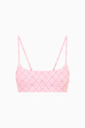 Pink bow patterned sports bra top on a white background