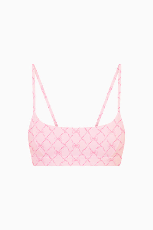 Pink bow patterned sports bra top on a white background