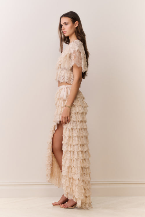 Woman wearing a beige lace set with a plain background