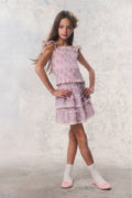 Young girl wearing a pink floral dress against a light background