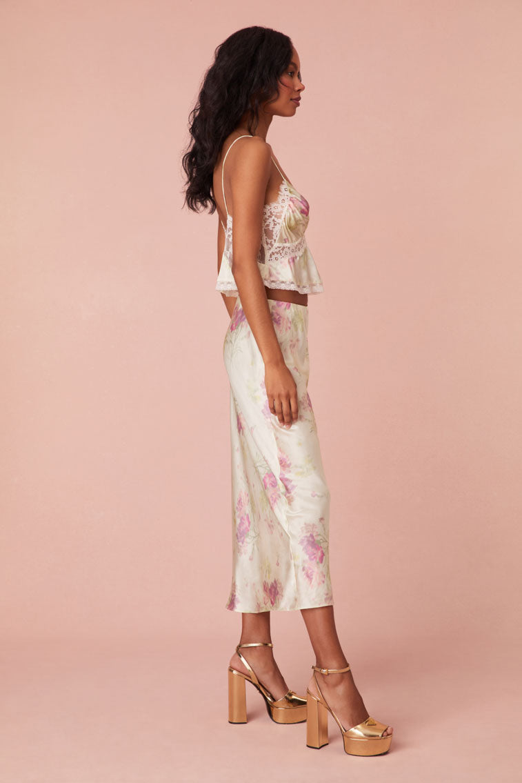 Floral midi skirt with a pencil slip shape. The skirt features a lightly elasticated waist, a fringe with a frayed edge at the bottom.