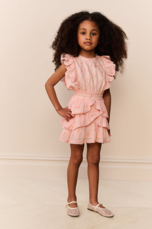 Child wearing a pink ruffled dress against a plain background
