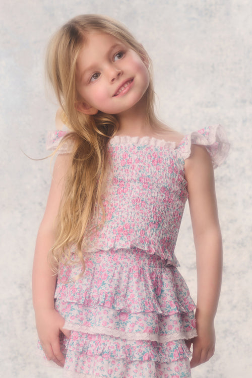 Young girl wearing a floral dress against a light background