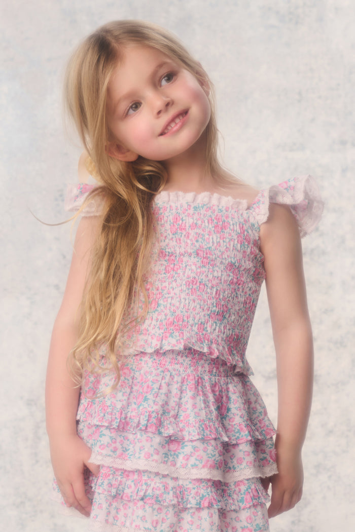 Young girl wearing a floral dress against a light background
