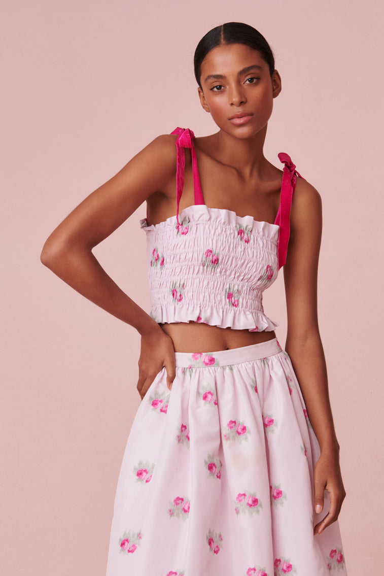 The smocked crop top with carnation print features pink double layered straps.