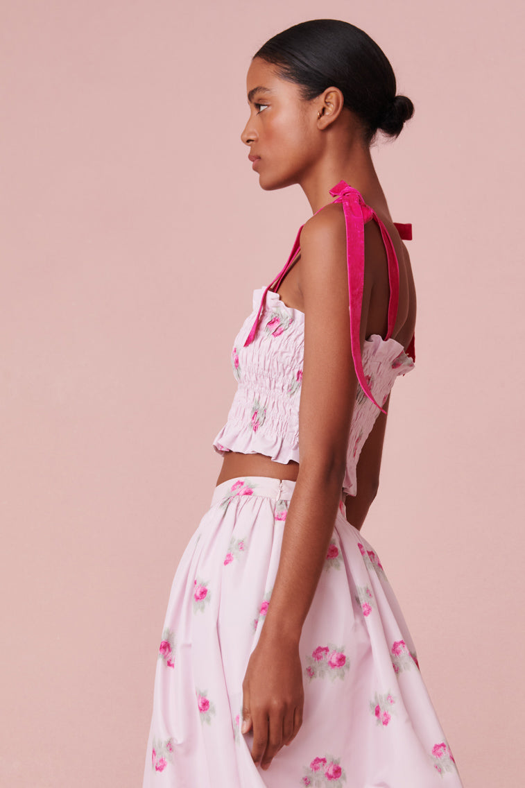 The smocked crop top with carnation print features pink double layered straps.