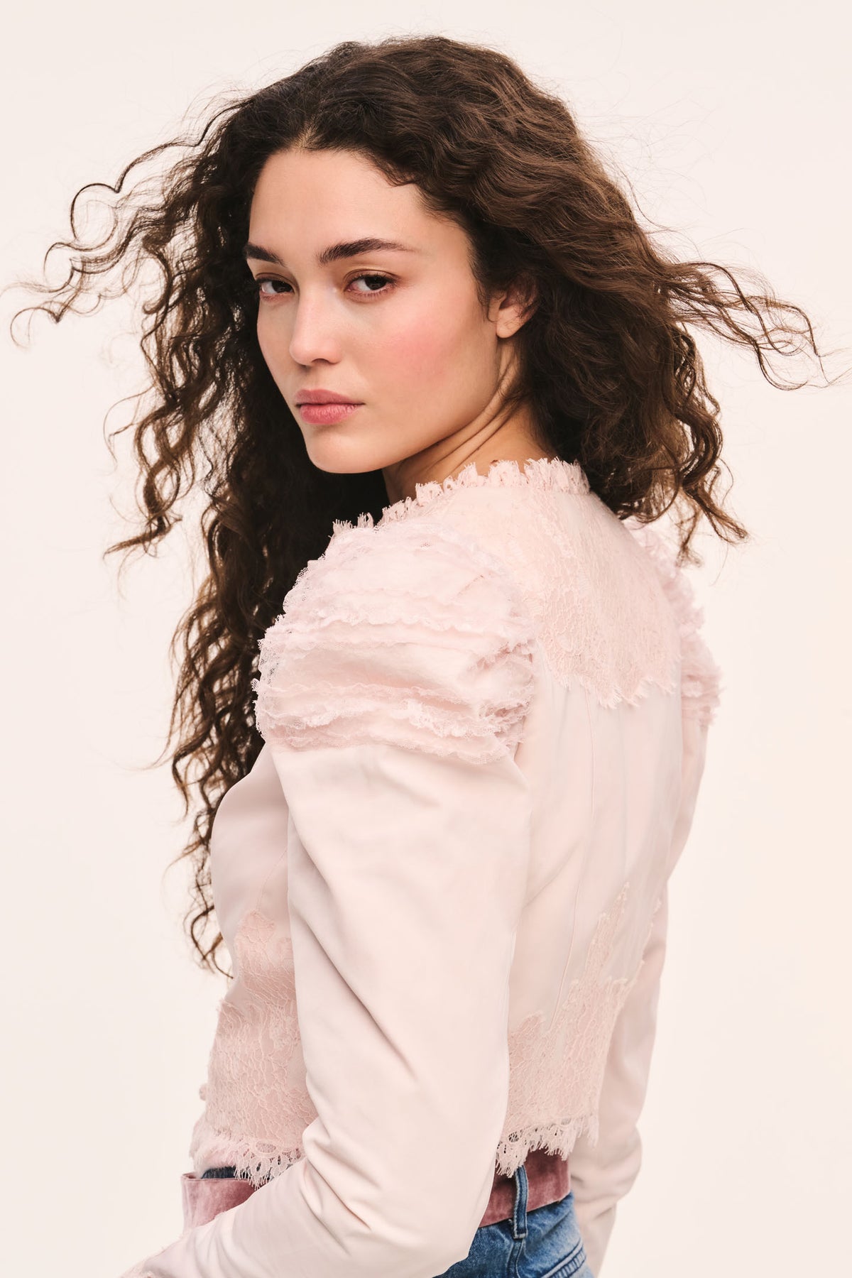 Light pink cropped jacket side view with puff sleeves, and lace-trim ruffle edges