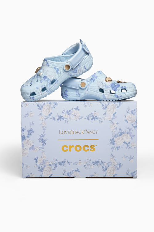 Blue floral Crocs shoes on a matching box with 'LoveShackFancy' branding.