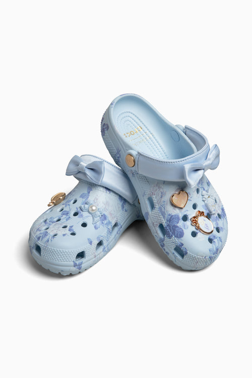 Pair of light blue croc clogs sandals with floral patterns on a white background