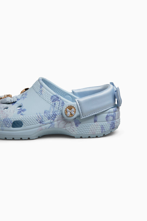 Pair of light blue croc clogs sandals with floral patterns on a white background
