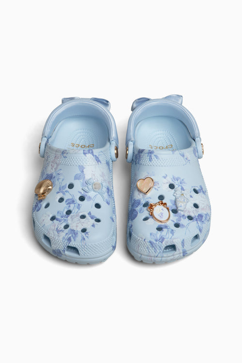 Pair of light blue croc clogs sandals with floral patterns on a white background
