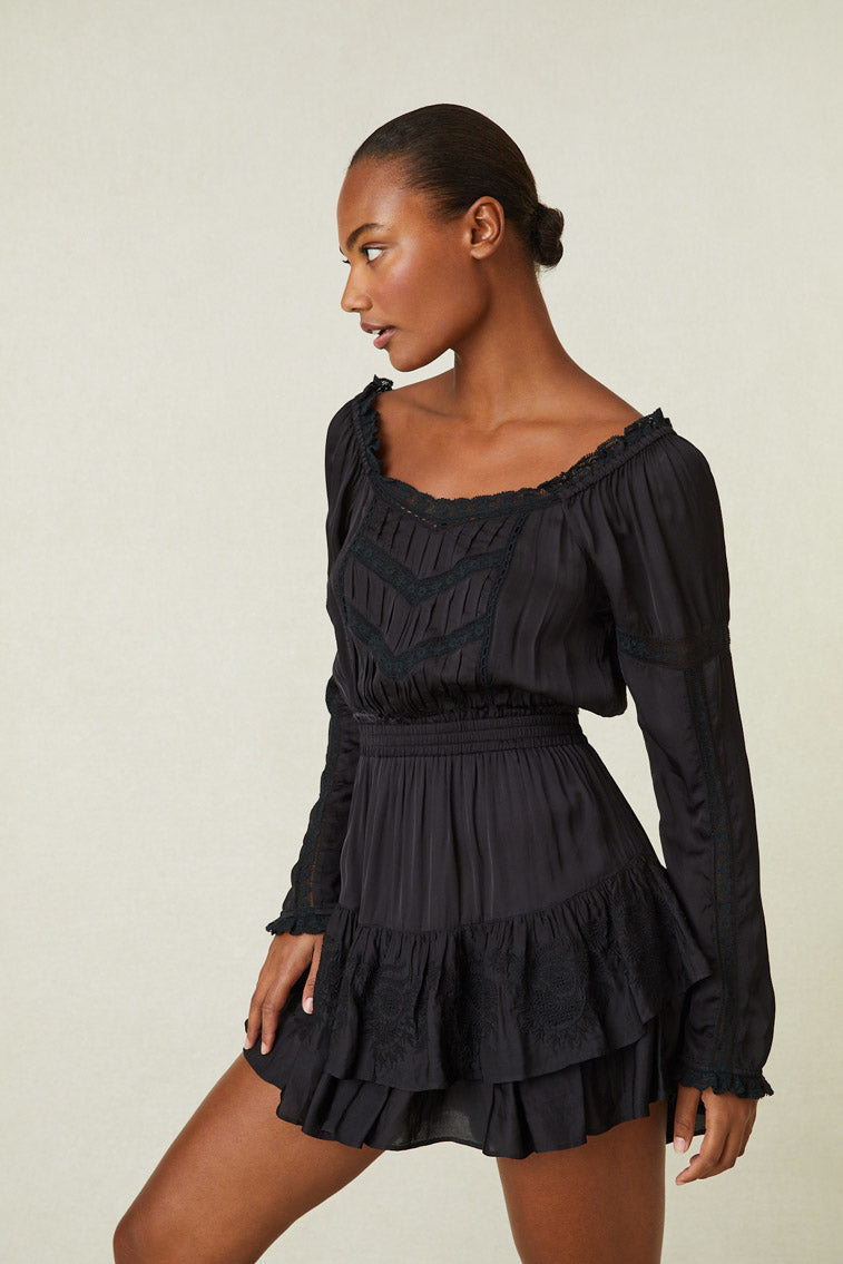 Model wearing black ruffle mini skirt with lace hem on the ruffles.