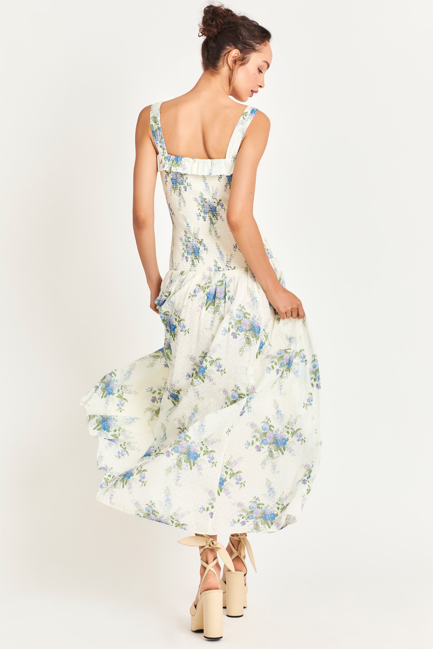 White Maxi dress with a blue heirloom bouquet print on a soft textured dot cotton fabric and a smocked bodice that releases into a sweeping A-line skirt. 