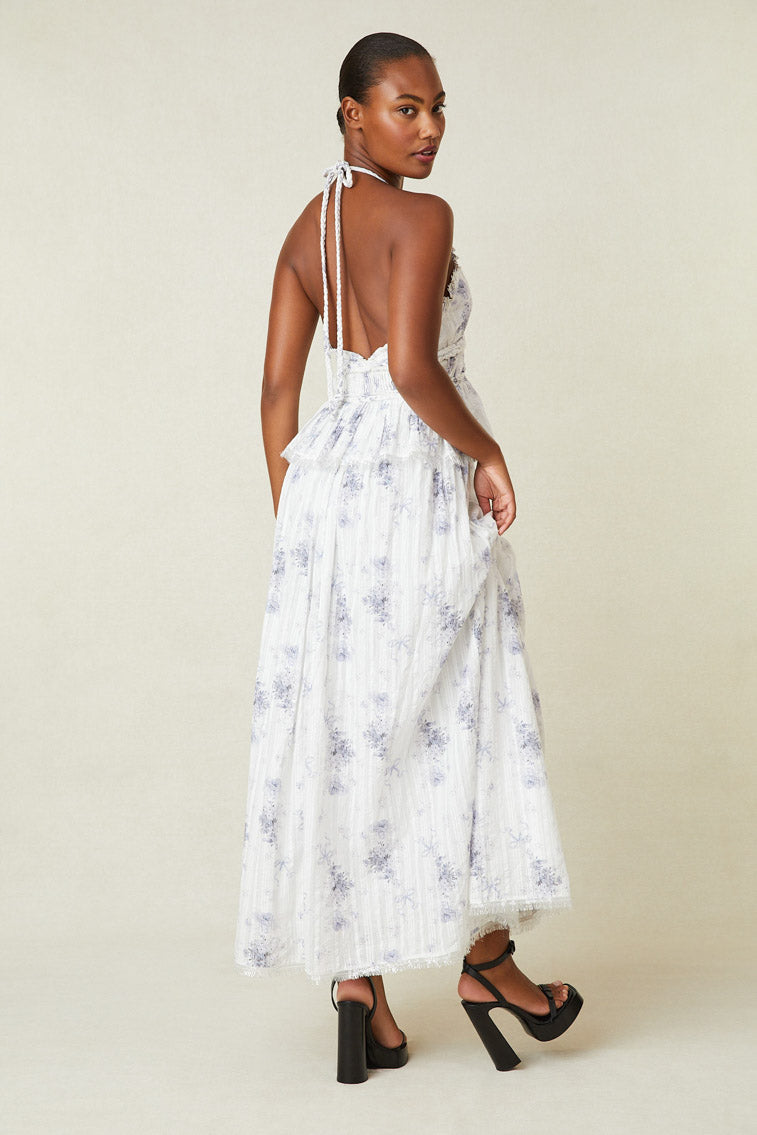 Back image of model wearing white and purple floral halter dress