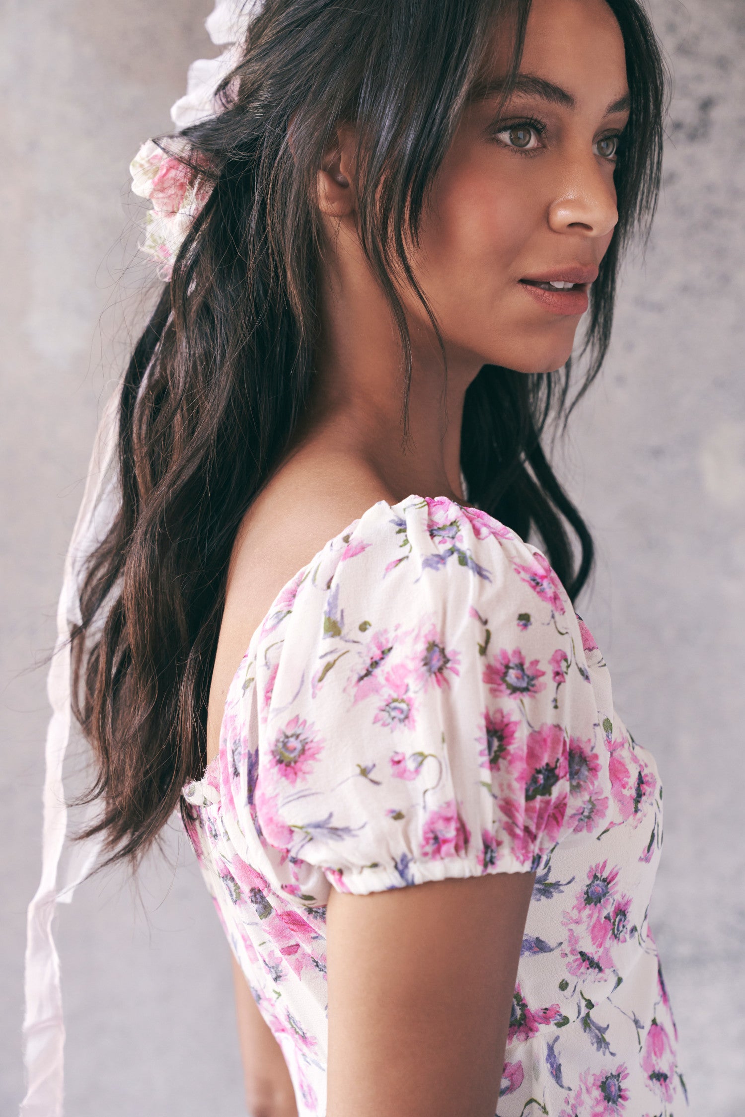 Close up image detailing sleeves and floral pattern on pink and white short sleeve maxi dress