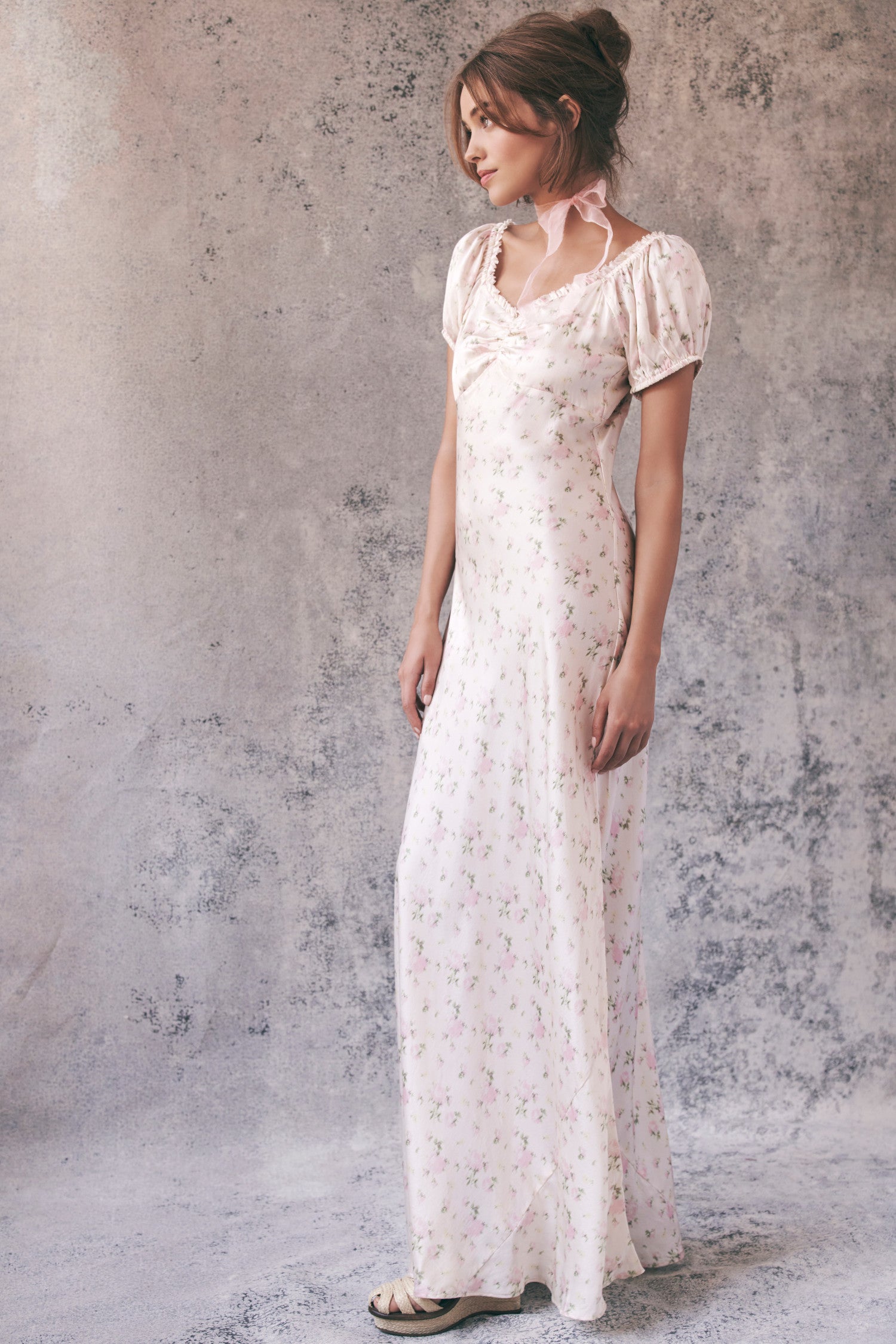 Side image of model wearing cream floral maxi dress
