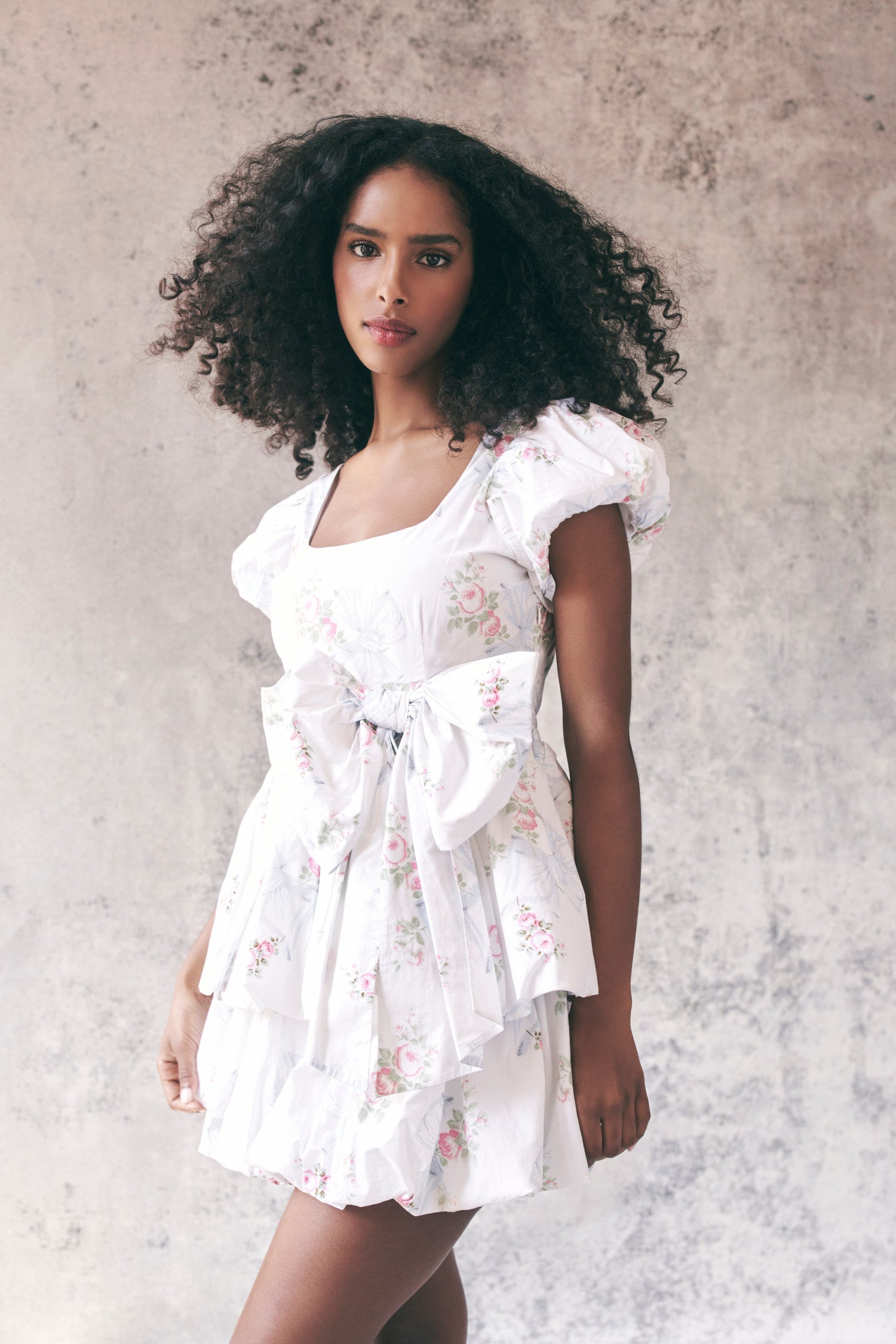 Model wearing white floral babydoll mini dress