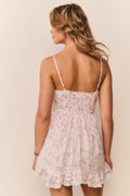 Woman wearing a floral dress mini with thin straps on a beige background