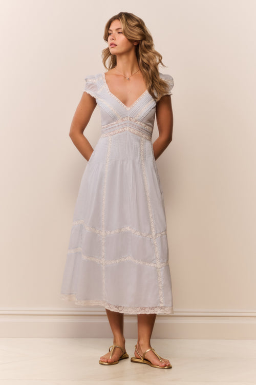 Woman wearing a light blue dress against a plain background