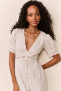 Woman wearing short sleeve white lace eyelet cutout long dress