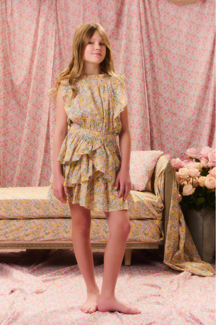 Girls floral printed dress with a ruffle-trimmed collar, buttons down center front, flutter sleeves, an elastic waist and overlapping asymmetrical ruffles at the skirt.