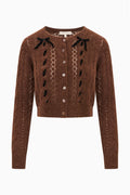 Front view: brown alpaca-blend ribbon cardigan with bows at shoulders and buttoned knit placket