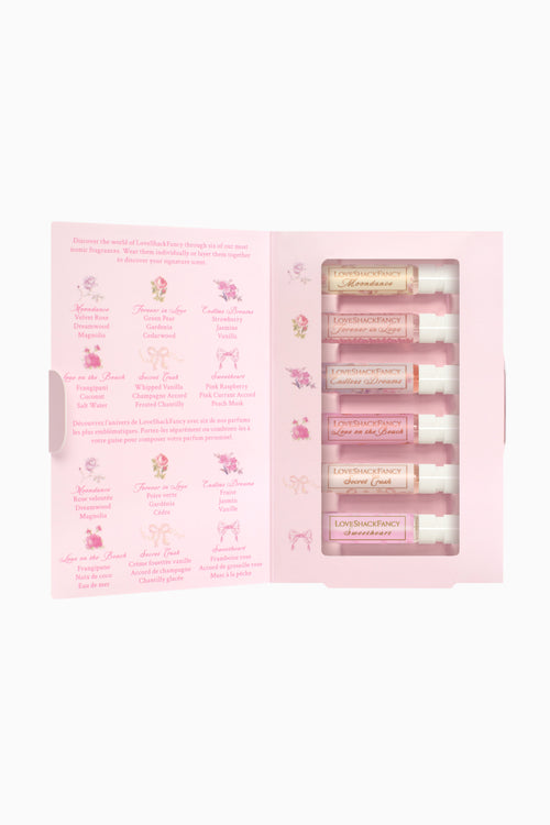 Set of perfumes in a pink packaging with product descriptions on a white background
