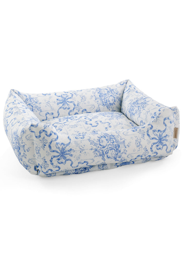 Dog bed with a bow and floral print.