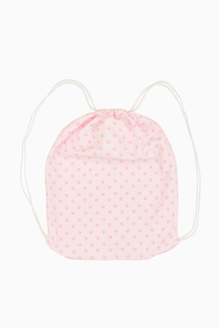 Pink drawstring bag with white polka dots on a white background