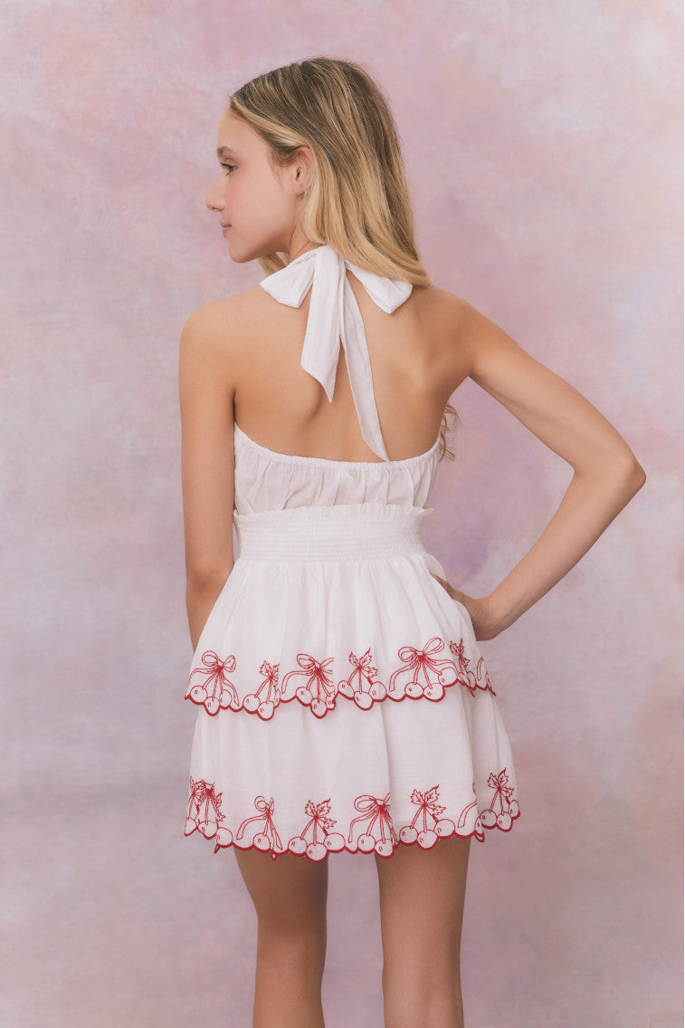 White halter v-neck dress with elastic waistband and cherry embroidery on the two tiered skirt for girls.