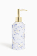 Floral-patterned soap dispenser with gold pump on a white background