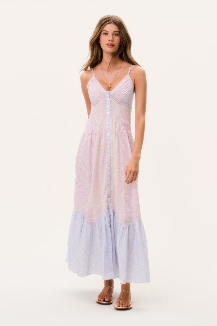 Woman wearing a light pink and blue dress sleeveless long dress on a white background