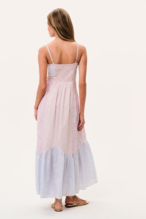 Woman wearing a light pink and blue dress sleeveless long dress on a white background