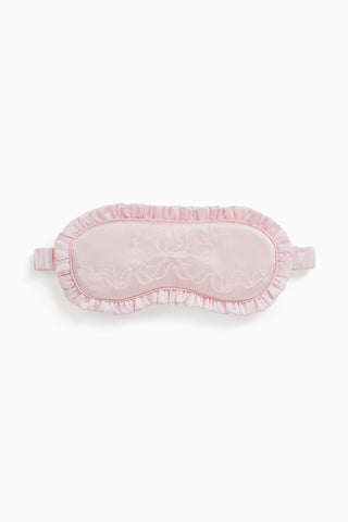 Pink eye mask with lace details on a white background