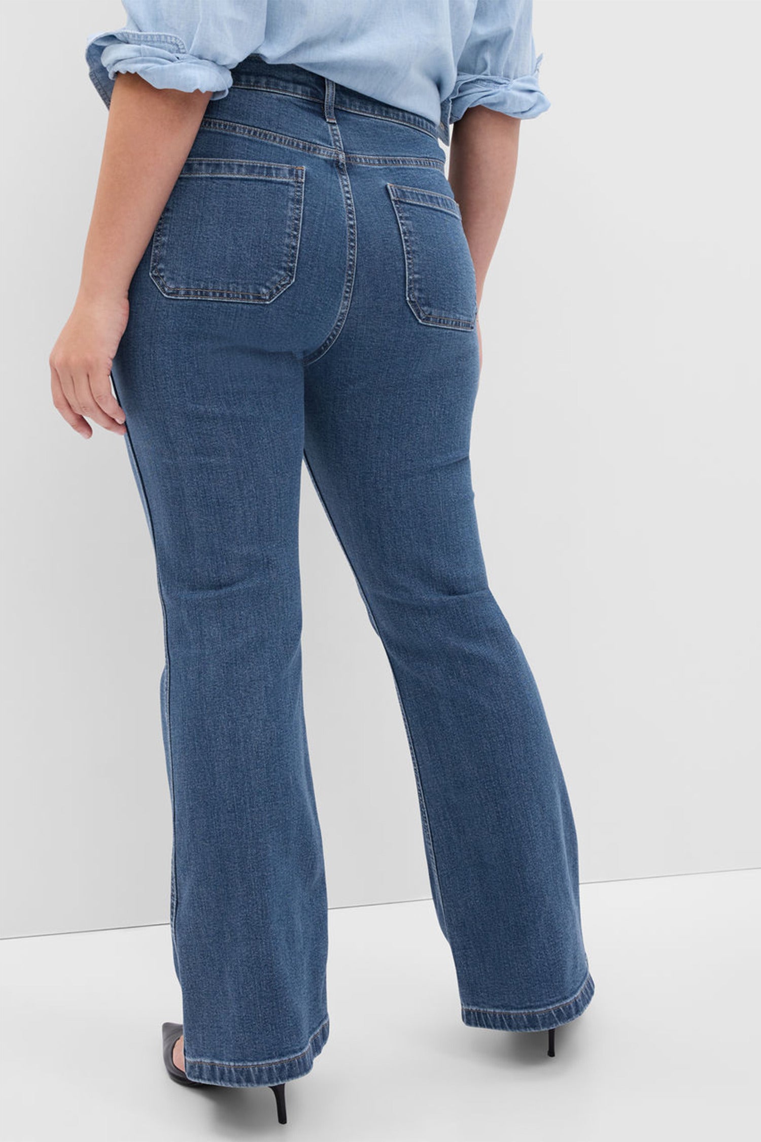 Model wearing blue high rise flare jeans