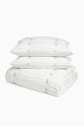 Stack of white pillows and duvet cover on a white background